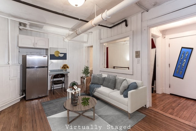 living room featuring wooden walls and dark hardwood / wood-style floors