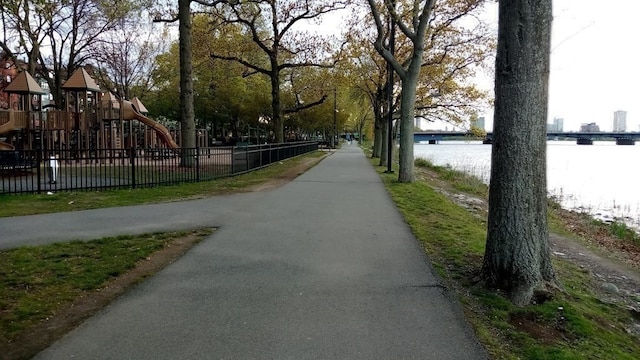 view of home's community with a playground and a water view