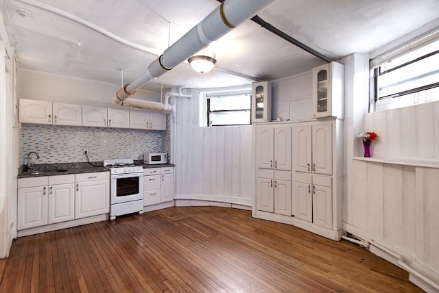 kitchen featuring white cabinetry, sink, white appliances, dark hardwood / wood-style flooring, and decorative backsplash