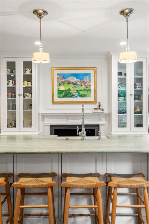 bar area with a fireplace and hanging light fixtures