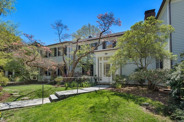 view of front of home featuring a chimney and a front lawn