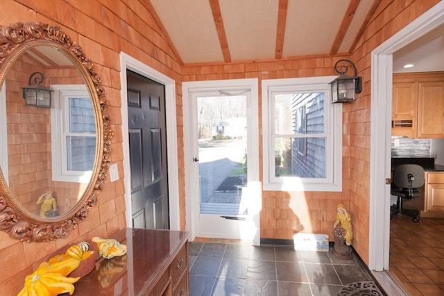 doorway to outside with vaulted ceiling with beams and wood walls