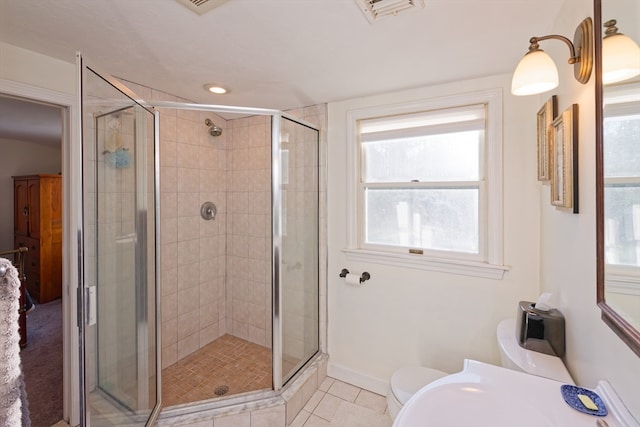 bathroom with a shower with door, tile patterned flooring, and toilet