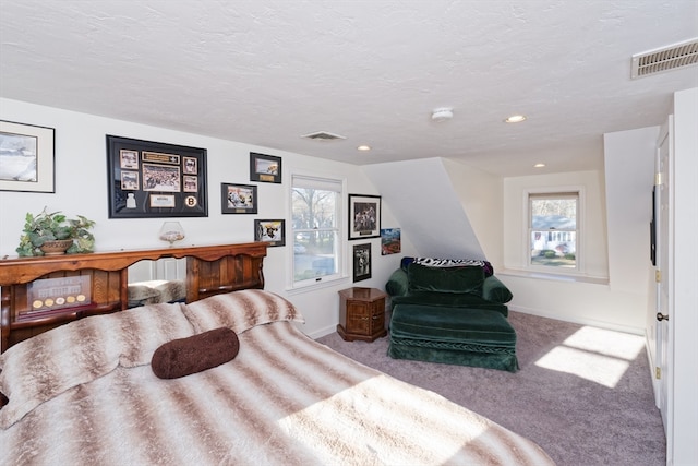 bedroom featuring light colored carpet and a textured ceiling