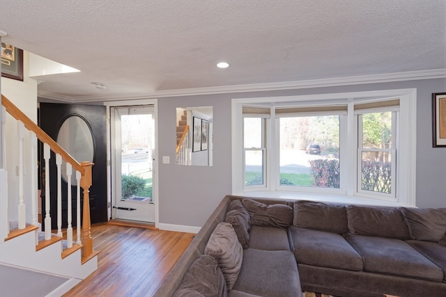 living room with crown molding, light hardwood / wood-style flooring, and a textured ceiling