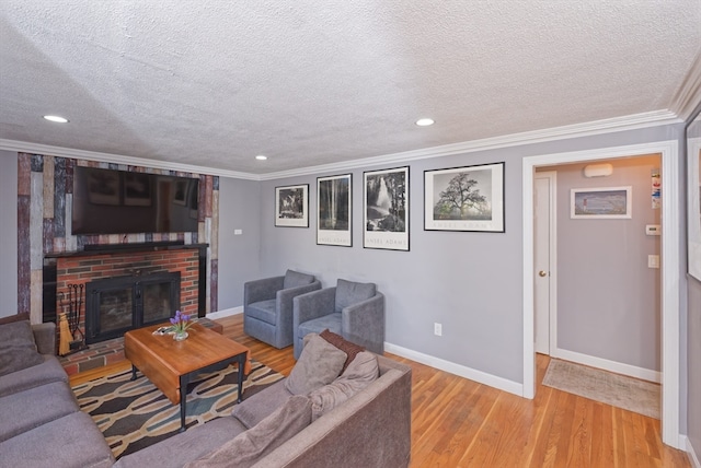 living room featuring a brick fireplace, a textured ceiling, and light hardwood / wood-style flooring