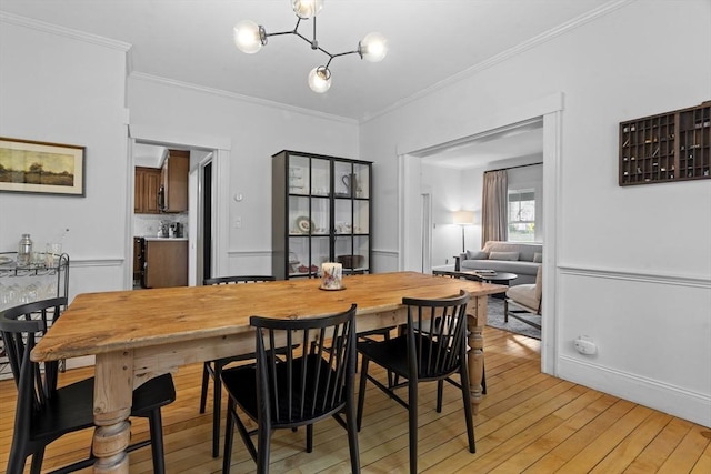 181 Lowell St, Andover, MA 01810 - dining space featuring light wood-style floors, ornamental molding, and a chandelier