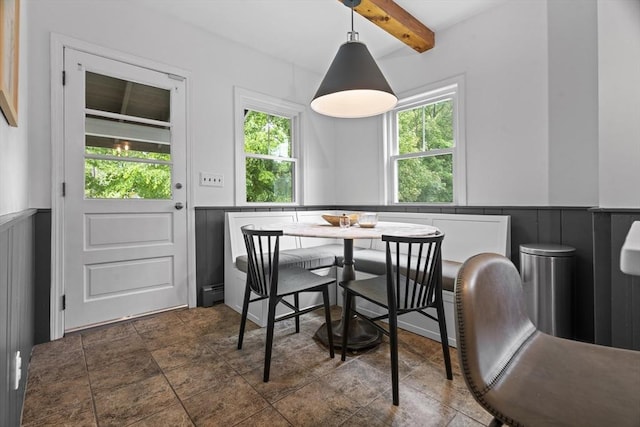 181 Lowell St, Andover, MA 01810 - dining area with a wainscoted wall, beam ceiling, a decorative wall, a baseboard radiator, and dark stone finish floors