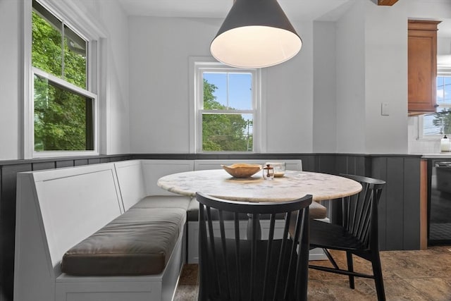 181 Lowell St, Andover, MA 01810 - dining room featuring a wainscoted wall, stone finish flooring, and a decorative wall