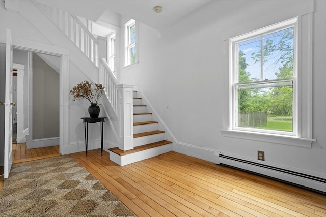 181 Lowell St, Andover, MA 01810 - stairway featuring a baseboard heating unit and hardwood / wood-style floors