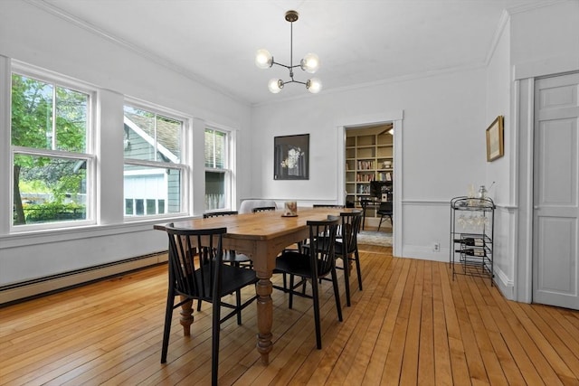 181 Lowell St, Andover, MA 01810 - dining space with ornamental molding, a chandelier, light wood-type flooring, built in shelves, and a baseboard heating unit