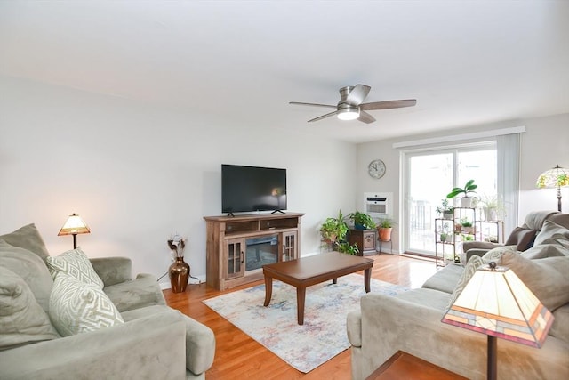 living room with light wood finished floors, a ceiling fan, and a wall mounted AC