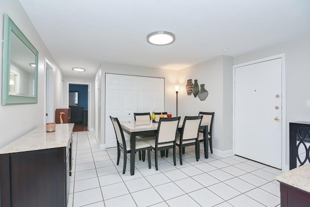 dining area featuring light tile patterned flooring and baseboards
