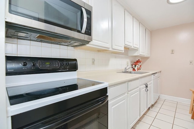 kitchen featuring range with electric cooktop, stainless steel microwave, white cabinets, and baseboards