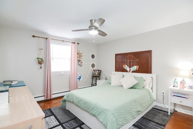 bedroom featuring ceiling fan, baseboard heating, and wood finished floors