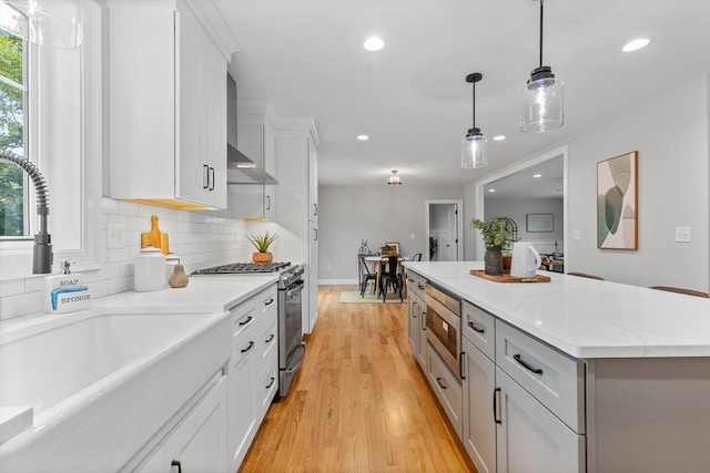 kitchen with white cabinets, decorative light fixtures, stainless steel appliances, and a kitchen island