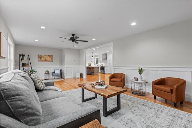 living room featuring ceiling fan and light hardwood / wood-style floors