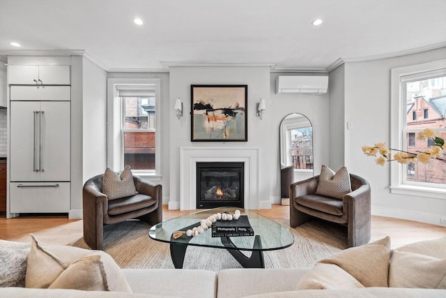 living room with light wood finished floors, ornamental molding, a wealth of natural light, and an AC wall unit