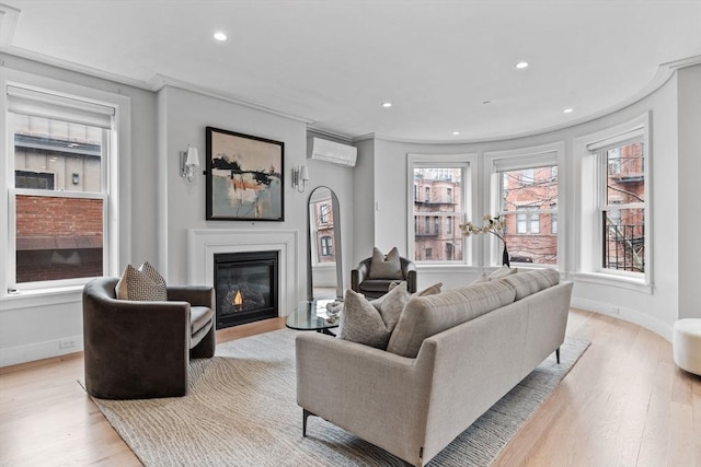 living area with baseboards, a glass covered fireplace, an AC wall unit, light wood-type flooring, and recessed lighting