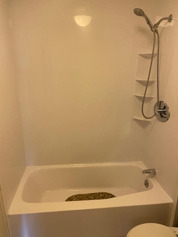 bathroom with washtub / shower combination and toilet