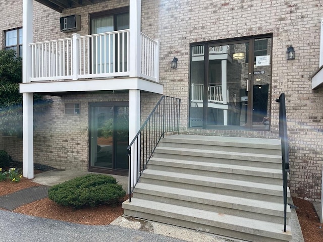property entrance featuring brick siding and a balcony