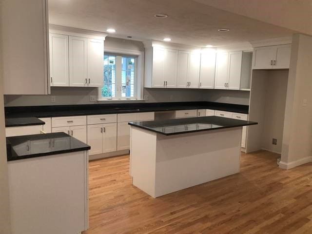 kitchen featuring white cabinetry, a center island, and light hardwood / wood-style flooring