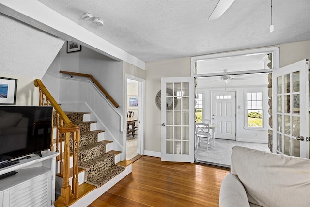 entrance foyer featuring ceiling fan, a textured ceiling, and wood-type flooring