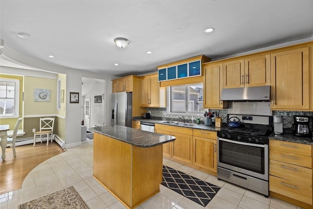 kitchen featuring light tile patterned floors, appliances with stainless steel finishes, a center island, and plenty of natural light