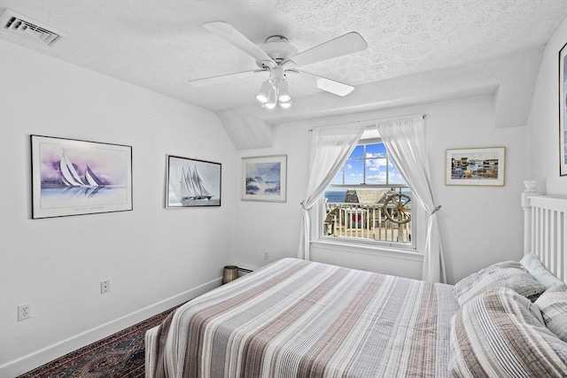 bedroom with ceiling fan and a textured ceiling