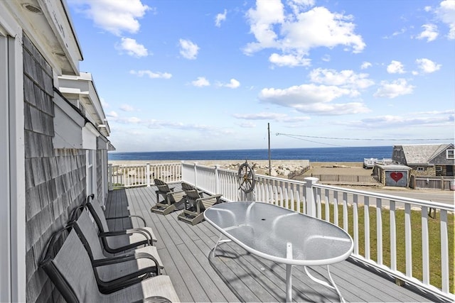 wooden terrace featuring a water view and a lawn