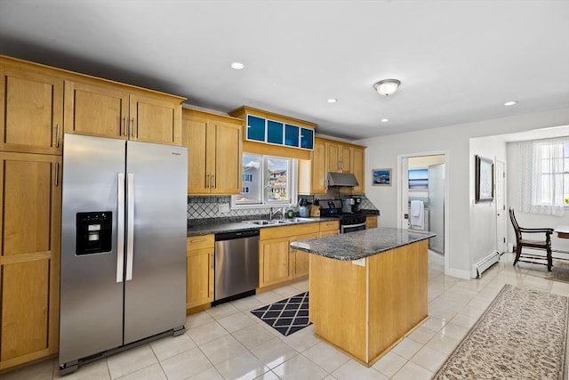 kitchen with a wealth of natural light, appliances with stainless steel finishes, sink, and a center island