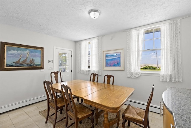 dining area with a textured ceiling, a wealth of natural light, light tile patterned floors, and a baseboard radiator