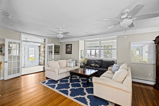 living room featuring a baseboard heating unit, dark hardwood / wood-style flooring, french doors, and a textured ceiling