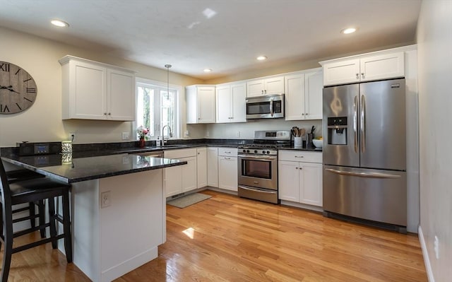 34 Bates St Unit 34, Abington, MA 02351 - kitchen featuring stainless steel appliances, a sink, a peninsula, white cabinets, and light wood-type flooring