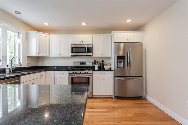 34 Bates St Unit 34, Abington, MA 02351 - kitchen featuring appliances with stainless steel finishes, white cabinets, a sink, hanging light fixtures, and dark stone countertops