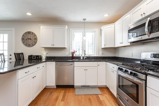 34 Bates St Unit 34, Abington, MA 02351 - kitchen with appliances with stainless steel finishes, a sink, a peninsula, white cabinets, and plenty of natural light