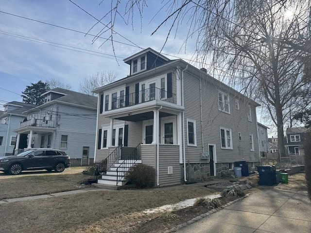 american foursquare style home featuring a balcony