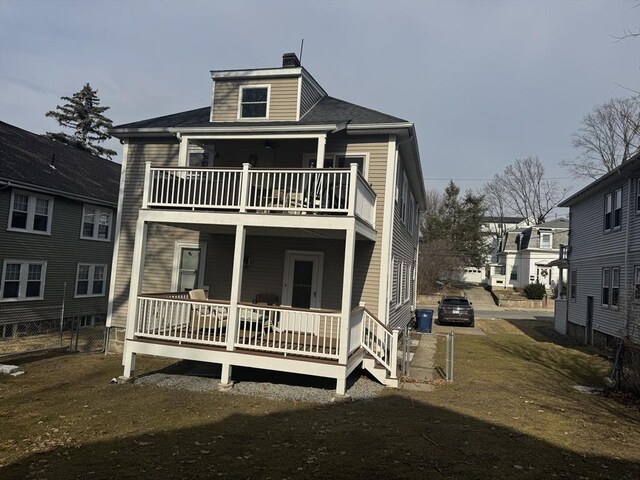 rear view of property with fence and a chimney