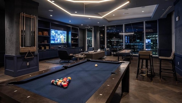 playroom with a tray ceiling, built in features, pool table, and dark parquet flooring