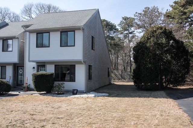 view of front of home featuring a front yard and roof with shingles