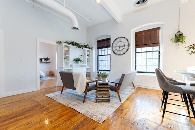 dining area featuring beamed ceiling, a healthy amount of sunlight, and light hardwood / wood-style floors