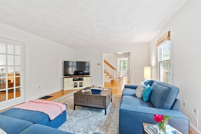 living room with wood finished floors, stairs, and baseboards