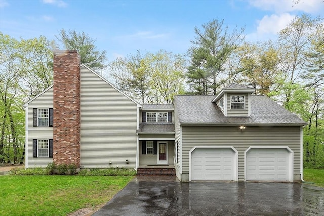 view of front of house with asphalt driveway, a shingled roof, an attached garage, a front lawn, and a chimney