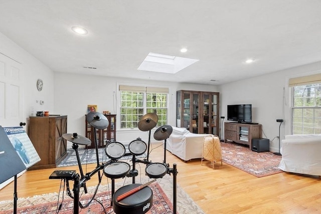 bedroom with a skylight, light wood finished floors, and recessed lighting