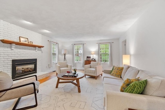 living area featuring light wood-style flooring and a brick fireplace
