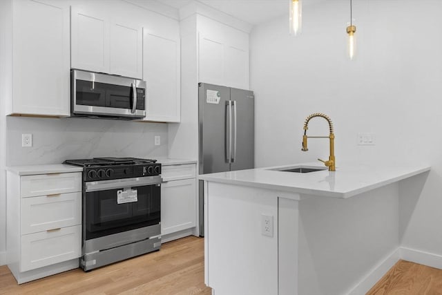7 Denvir St Unit 2, Boston, MA 02124 - kitchen featuring appliances with stainless steel finishes, a sink, light wood-style flooring, and white cabinetry
