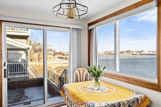 dining space with a chandelier and a water view