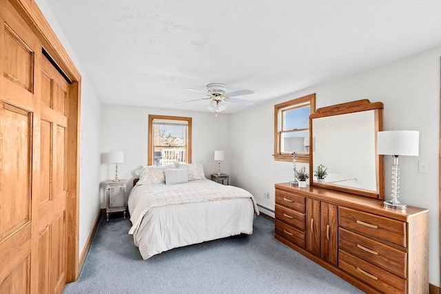 bedroom featuring baseboards, a baseboard heating unit, dark carpet, and a ceiling fan