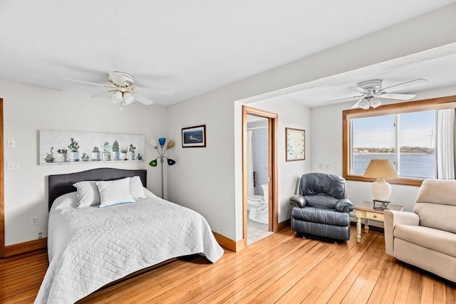 bedroom featuring ensuite bathroom, wood finished floors, a ceiling fan, and baseboards