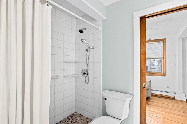 bathroom featuring a baseboard heating unit, a stall shower, wood finished floors, and toilet